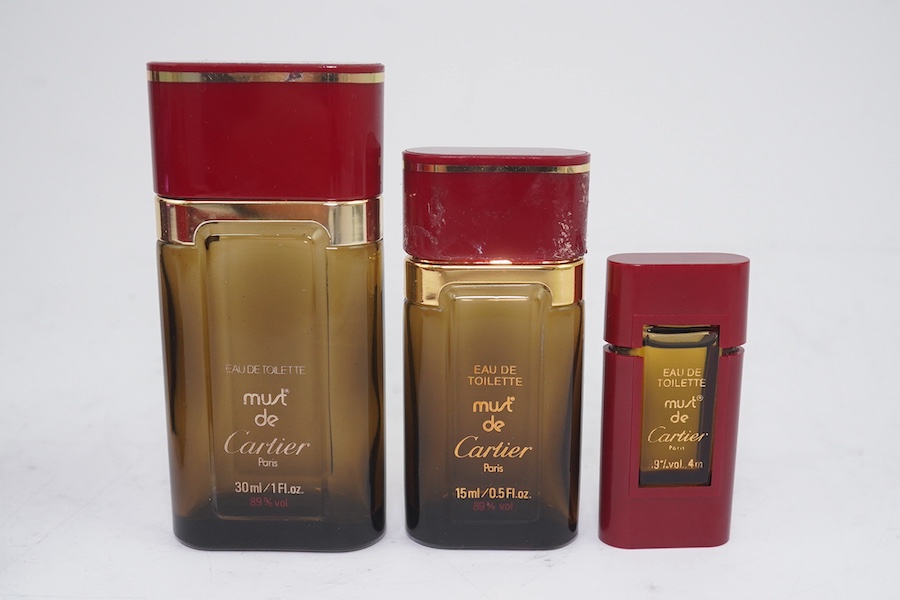 An assortment of Must de Cartier bordeaux leather accessories